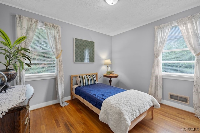 8702 Holly Hill Rd, Richmond, VA 23229 - bedroom with a textured ceiling, wood finished floors, and multiple windows
