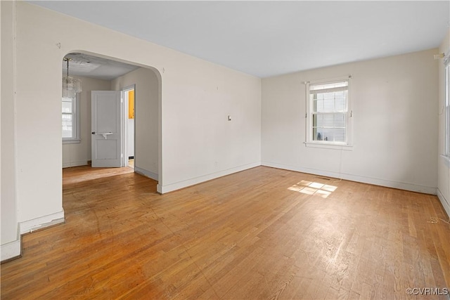 414 John St, Ashland, VA 23005 - empty room featuring plenty of natural light, arched walkways, and light wood-style flooring
