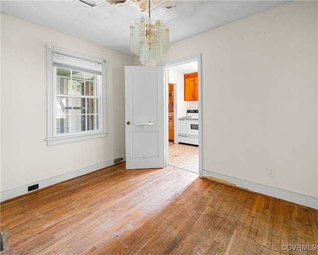 414 John St, Ashland, VA 23005 - empty room with a chandelier and light wood-style flooring