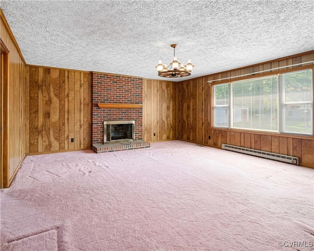 414 John St, Ashland, VA 23005 - unfurnished living room featuring baseboard heating, a chandelier, wood walls, carpet floors, and a brick fireplace