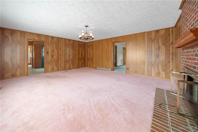 414 John St, Ashland, VA 23005 - unfurnished living room with a chandelier, a textured ceiling, wood walls, a baseboard radiator, and light carpet