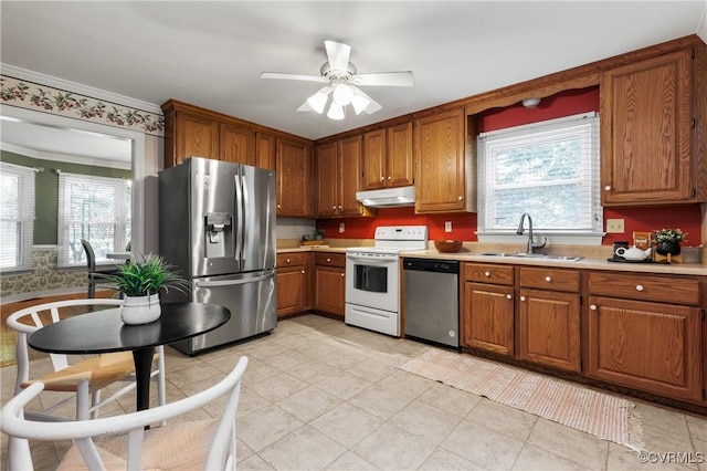 14106 Pensive Pl, Midlothian, VA 23112 - kitchen with appliances with stainless steel finishes, under cabinet range hood, light countertops, brown cabinetry, and plenty of natural light