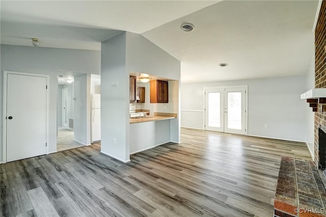 7131 Brook Way, Mechanicsville, VA 23111 - unfurnished living room with vaulted ceiling, wood finished floors, a brick fireplace, and french doors