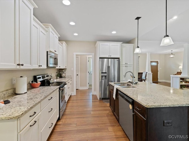 1130 Sparrows Ln, Powhatan, VA 23139 - kitchen with stainless steel appliances, light wood-type flooring, white cabinetry, a center island with sink, and pendant lighting