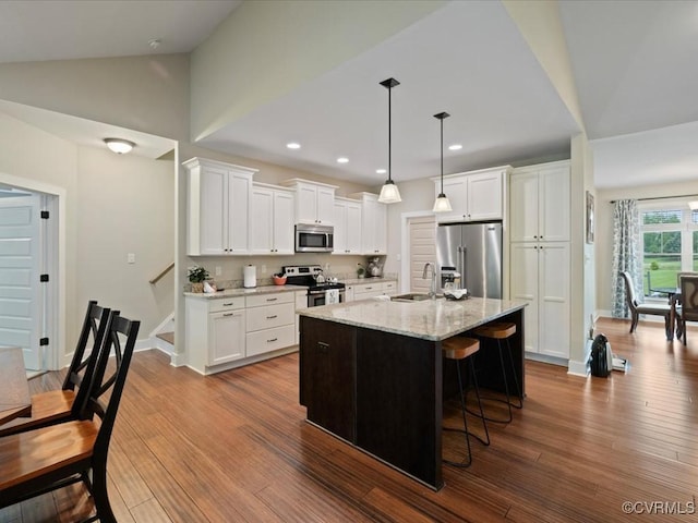 1130 Sparrows Ln, Powhatan, VA 23139 - kitchen featuring appliances with stainless steel finishes, dark wood-style flooring, white cabinets, a kitchen breakfast bar, and lofted ceiling