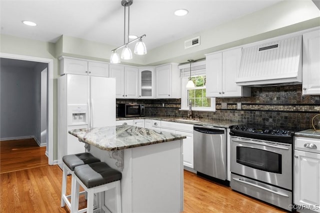 4709 Tameo Ct, Glen Allen, VA 23060 - kitchen featuring appliances with stainless steel finishes, range hood, white cabinetry, decorative backsplash, and recessed lighting