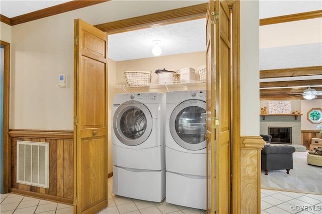 2801 Starling Dr, Williamsburg, VA 23185 - laundry area with light tile patterned floors, separate washer and dryer, a fireplace, crown molding, and ceiling fan