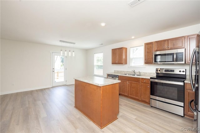 1712 Binford Ct, Cobbs Creek, VA 23223 - kitchen featuring stainless steel appliances, a center island, light wood-style flooring, and brown cabinets