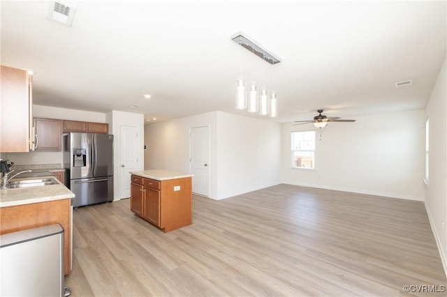 1712 Binford Ct, Cobbs Creek, VA 23223 - kitchen featuring stainless steel fridge, a kitchen island, brown cabinets, ceiling fan, and light wood-style floors