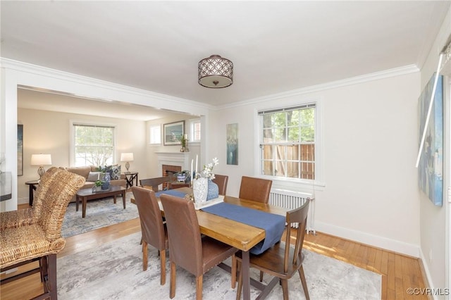 4024 W Grace St, Richmond, VA 23230 - dining space with light wood finished floors, a fireplace, and ornamental molding