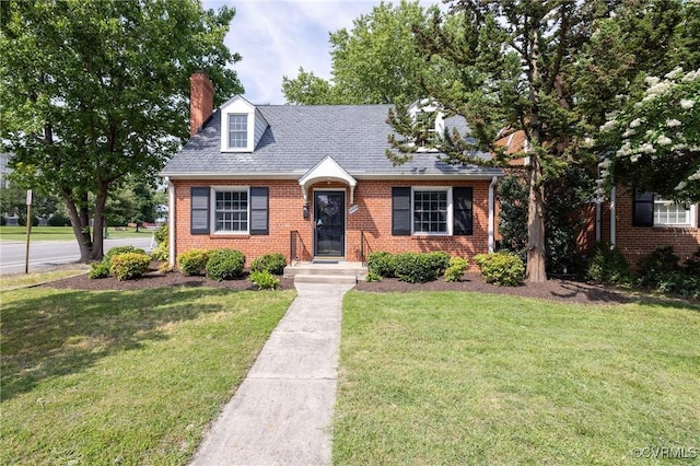 4024 W Grace St, Richmond, VA 23230 - cape cod-style house with a front yard, brick siding, and a chimney