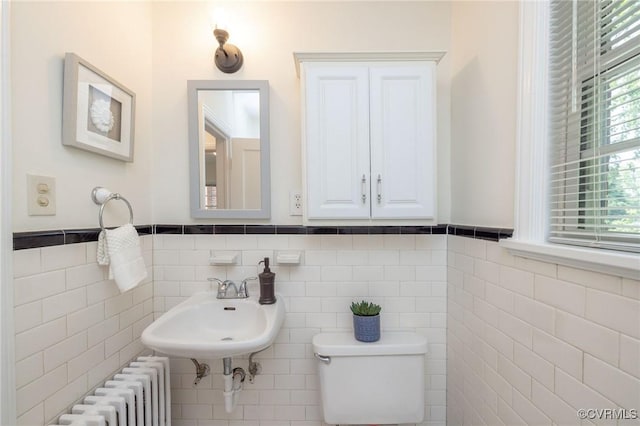 4024 W Grace St, Richmond, VA 23230 - half bath with radiator, tile walls, and a wainscoted wall