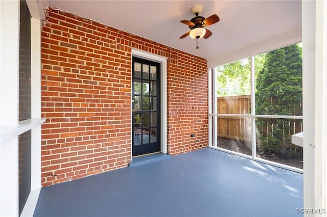 4024 W Grace St, Richmond, VA 23230 - unfurnished sunroom featuring brick wall, concrete floors, ceiling fan, and plenty of natural light