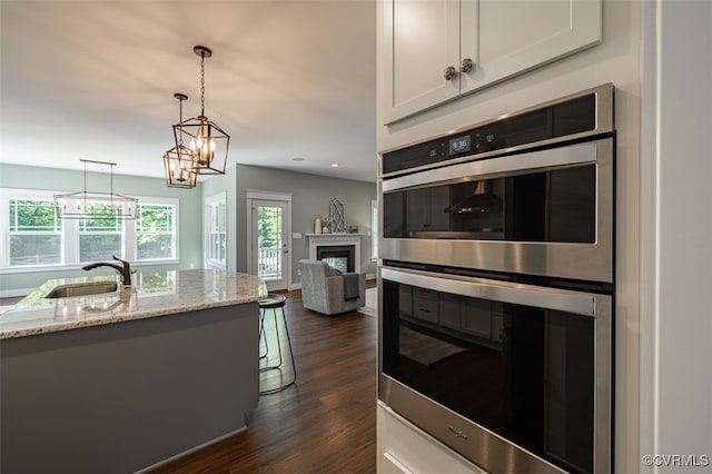 9377 Magnolia Blossom Rd, Ashland, VA 23005 - kitchen featuring stainless steel double oven, dark wood finished floors, light stone counters, white cabinets, and recessed lighting