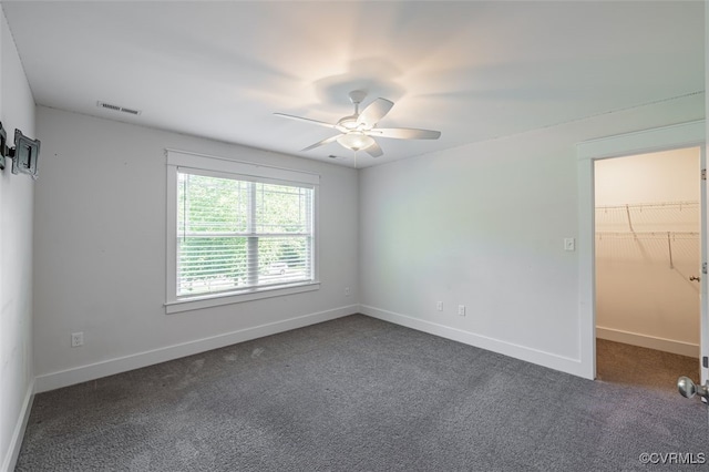 9377 Magnolia Blossom Rd, Ashland, VA 23005 - unfurnished bedroom featuring dark colored carpet, a walk in closet, and a ceiling fan