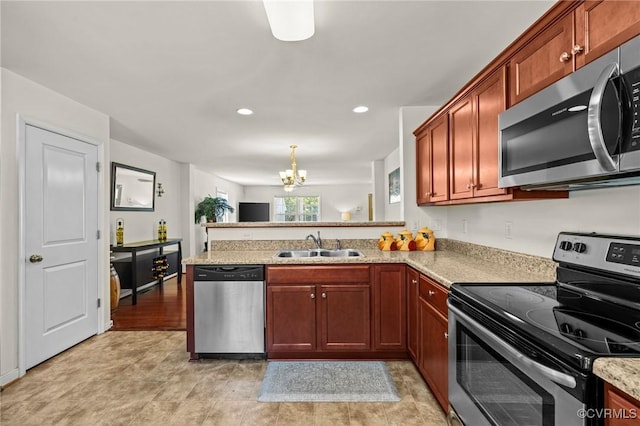 9949 Reymet Ct, North Chesterfield, VA 23237 - kitchen with appliances with stainless steel finishes, a chandelier, a peninsula, recessed lighting, and light stone counters