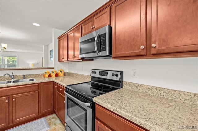 9949 Reymet Ct, North Chesterfield, VA 23237 - kitchen with stainless steel appliances, brown cabinetry, and a chandelier