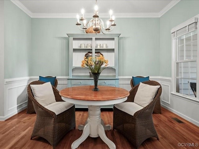 4416 Killiam Ct, Henrico, VA 23060 - dining space featuring a chandelier, wood finished floors, crown molding, a wainscoted wall, and a decorative wall