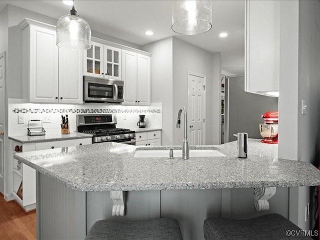 4416 Killiam Ct, Henrico, VA 23060 - kitchen with stainless steel appliances, white cabinets, a kitchen breakfast bar, light stone countertops, and recessed lighting