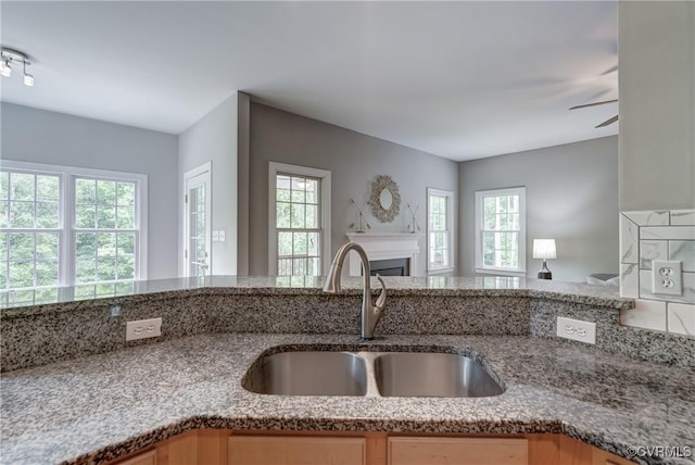 5501 Pine Needles Ter, Providence Forge, VA 23140 - kitchen with open floor plan, light stone countertops, a fireplace, and a ceiling fan