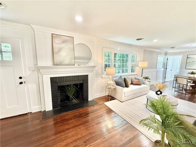7335 Cherokee Rd, Richmond, VA 23225 - living area featuring a decorative wall, ornamental molding, wood finished floors, plenty of natural light, and a fireplace