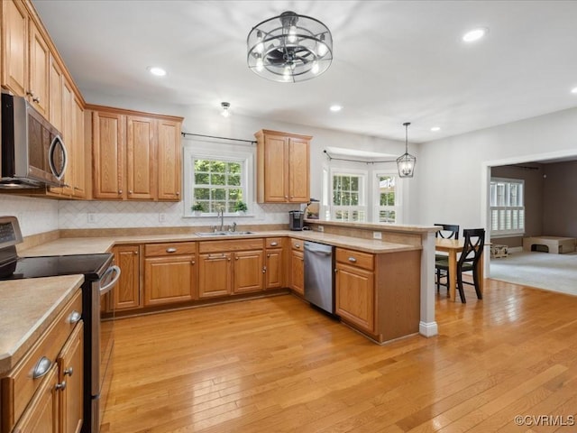 1960 Teal Ln, Powhatan, VA 23139 - kitchen featuring stainless steel appliances, a peninsula, light wood-style flooring, a chandelier, and recessed lighting
