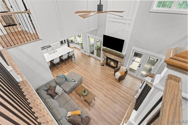 4788 Powhatan Lakes Rd, Powhatan, VA 23139 - living area with french doors, a stone fireplace, a high ceiling, healthy amount of natural light, and a ceiling fan