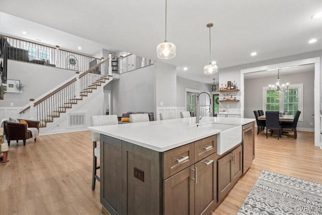 4788 Powhatan Lakes Rd, Powhatan, VA 23139 - kitchen featuring light wood-style flooring, stainless steel dishwasher, a kitchen breakfast bar, pendant lighting, and light countertops