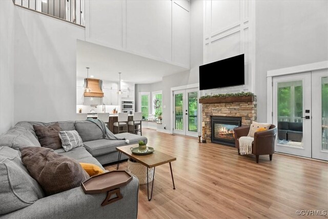 4788 Powhatan Lakes Rd, Powhatan, VA 23139 - living room with french doors, a towering ceiling, light wood-style flooring, and a fireplace