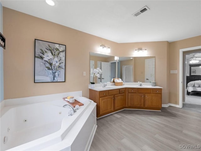 12306 Hollow Oak Ter, Midlothian, VA 23112 - ensuite bathroom featuring double vanity, a tub with jets, and wood finished floors