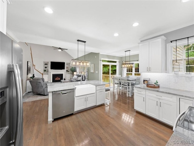 12306 Hollow Oak Ter, Midlothian, VA 23112 - kitchen featuring appliances with stainless steel finishes, a lit fireplace, ceiling fan, wood finished floors, and vaulted ceiling