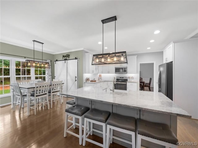 12306 Hollow Oak Ter, Midlothian, VA 23112 - kitchen with appliances with stainless steel finishes, a barn door, white cabinets, crown molding, and recessed lighting