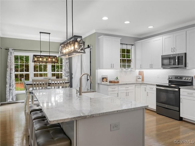 12306 Hollow Oak Ter, Midlothian, VA 23112 - kitchen featuring stainless steel appliances, a breakfast bar, backsplash, white cabinetry, and ornamental molding