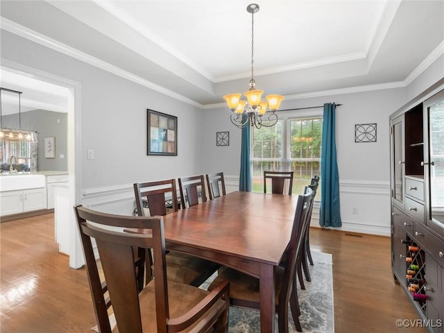 12306 Hollow Oak Ter, Midlothian, VA 23112 - dining area with a chandelier, light wood-style flooring, a raised ceiling, a wainscoted wall, and ornamental molding