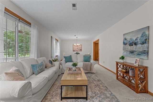 11192 Eventide Ln, Gloucester, VA 23061 - carpeted living room featuring a textured ceiling and a chandelier