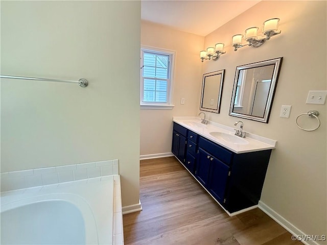 10342 Brickerton Dr, Mechanicsville, VA 23116 - bathroom featuring double vanity, a garden tub, and wood finished floors