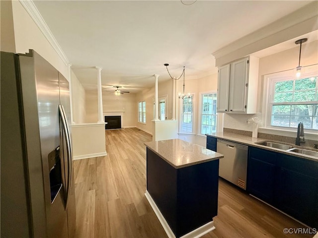 10342 Brickerton Dr, Mechanicsville, VA 23116 - kitchen featuring stainless steel appliances, light wood-style floors, ceiling fan, a kitchen island, and ornamental molding