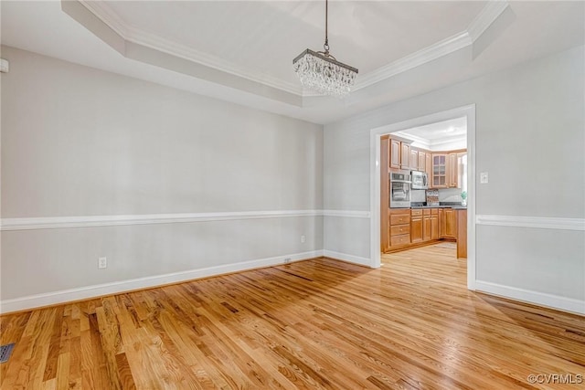 16494 Connie Hall Rd, Montpelier, VA 23192 - spare room featuring a raised ceiling, a chandelier, ornamental molding, and light wood-type flooring