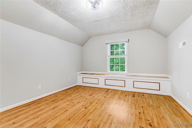 16494 Connie Hall Rd, Montpelier, VA 23192 - additional living space with wood finished floors, vaulted ceiling, and a textured ceiling