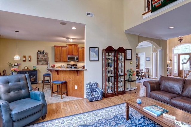 5669 Virginia Park Dr, Providence Forge, VA 23140 - living room featuring arched walkways, light wood-style floors, ornate columns, and a towering ceiling