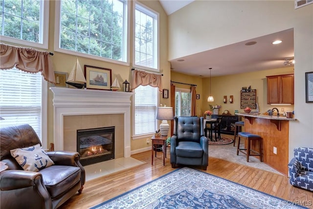 5669 Virginia Park Dr, Providence Forge, VA 23140 - living room featuring light wood-type flooring, a tiled fireplace, and high vaulted ceiling