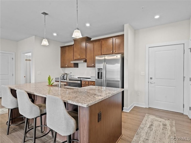 3700 Maze Runner Dr Unit 104, Midlothian, VA 23112 - kitchen with stainless steel appliances, under cabinet range hood, light wood finished floors, light stone countertops, and a center island with sink