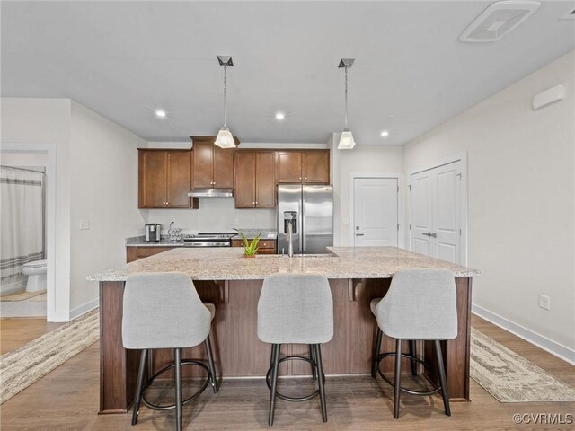 3700 Maze Runner Dr Unit 104, Midlothian, VA 23112 - kitchen with appliances with stainless steel finishes, a large island, light stone countertops, wood finished floors, and recessed lighting