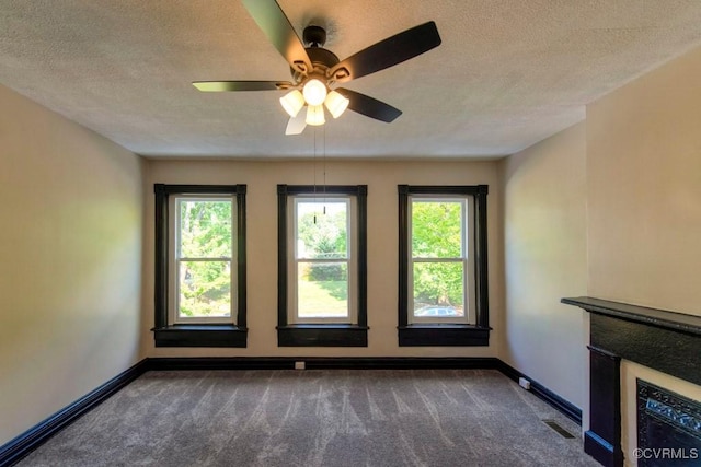 2921 E Marshall St, Richmond, VA 23223 - unfurnished room featuring dark colored carpet, a textured ceiling, plenty of natural light, and ceiling fan