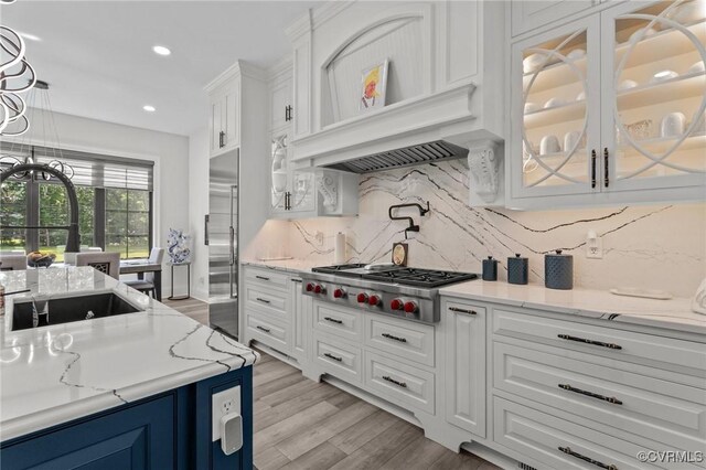 12313 Haybrook Ln, Henrico, VA 23059 - kitchen with appliances with stainless steel finishes, white cabinetry, light wood-style floors, blue cabinetry, and decorative backsplash