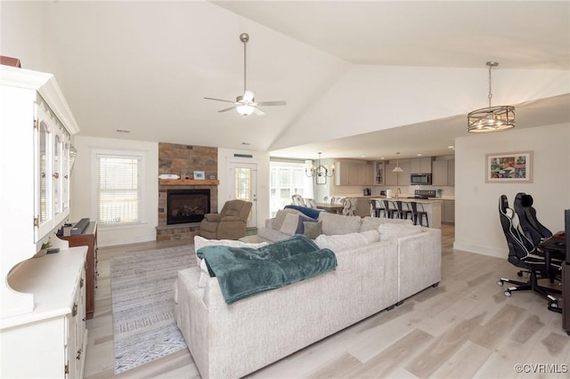 8851 Topeka Rd, Quinton, VA 23141 - living area with a chandelier, a stone fireplace, light wood-style floors, a ceiling fan, and high vaulted ceiling