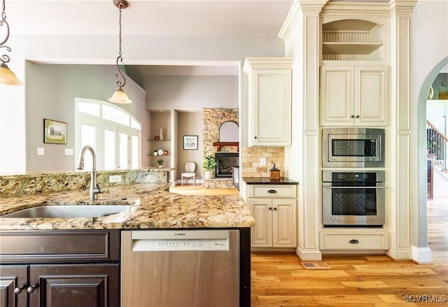2631 Royal Crest Dr, Midlothian, VA 23113 - kitchen featuring appliances with stainless steel finishes, cream cabinetry, light wood-style flooring, and healthy amount of natural light