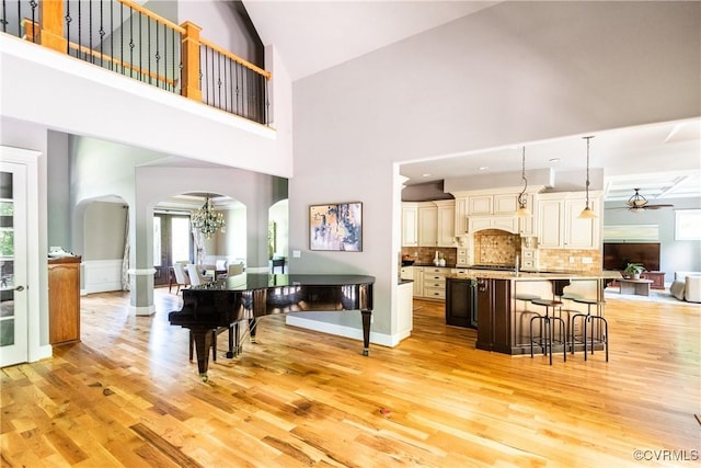 2631 Royal Crest Dr, Midlothian, VA 23113 - living room featuring arched walkways, light wood-type flooring, ceiling fan, high vaulted ceiling, and a chandelier
