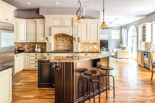 2631 Royal Crest Dr, Midlothian, VA 23113 - kitchen with cream cabinetry, light wood-type flooring, wine cooler, dark stone countertops, and recessed lighting