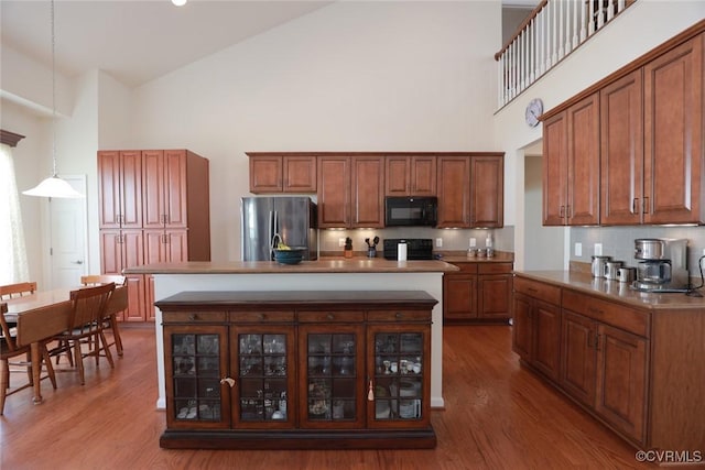 7822 James Blair Ln, New Kent, VA 23124 - kitchen featuring freestanding refrigerator, high vaulted ceiling, black microwave, wood finished floors, and glass insert cabinets